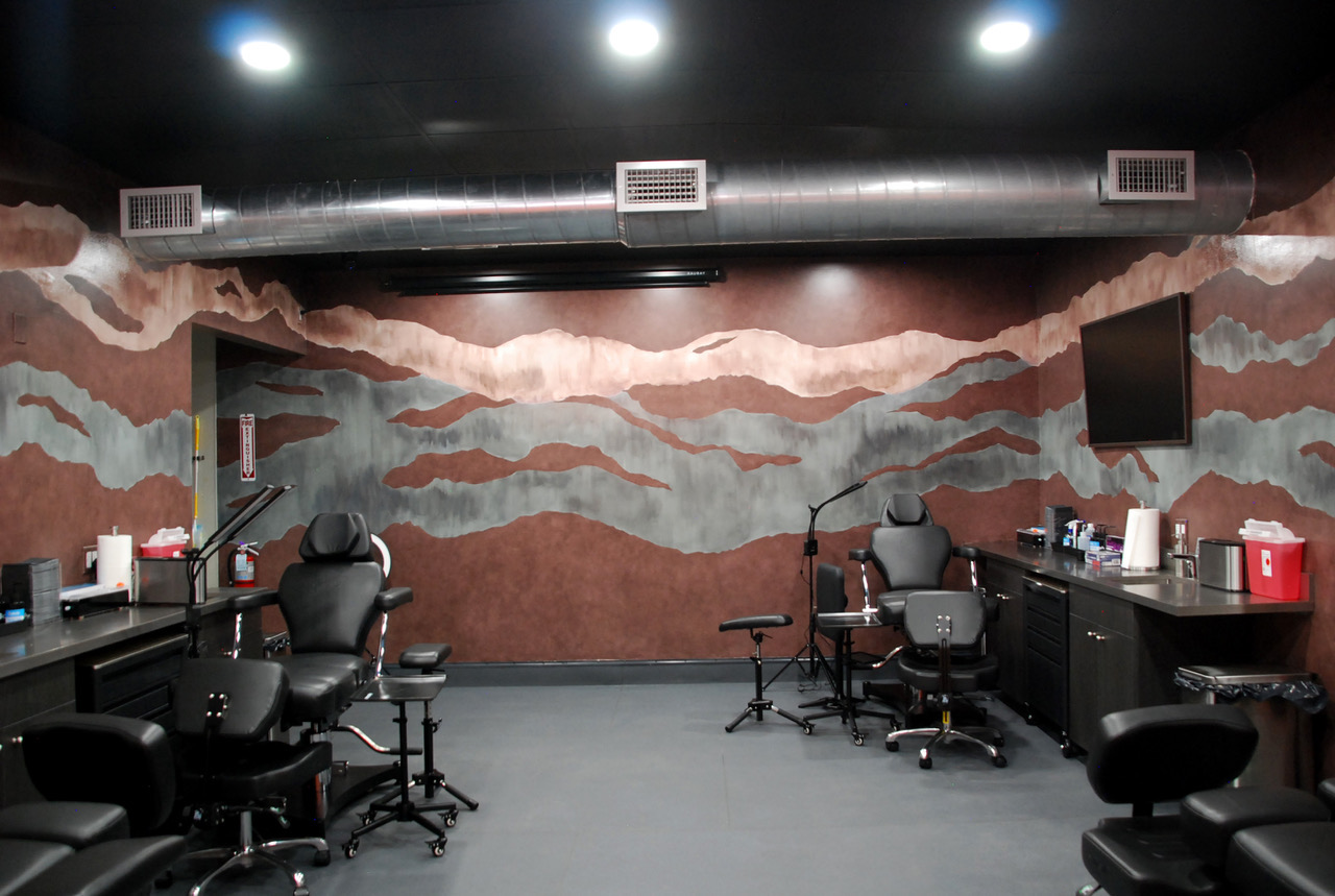 Tattoo stations beneath the mountain mural at Double Edge Ink